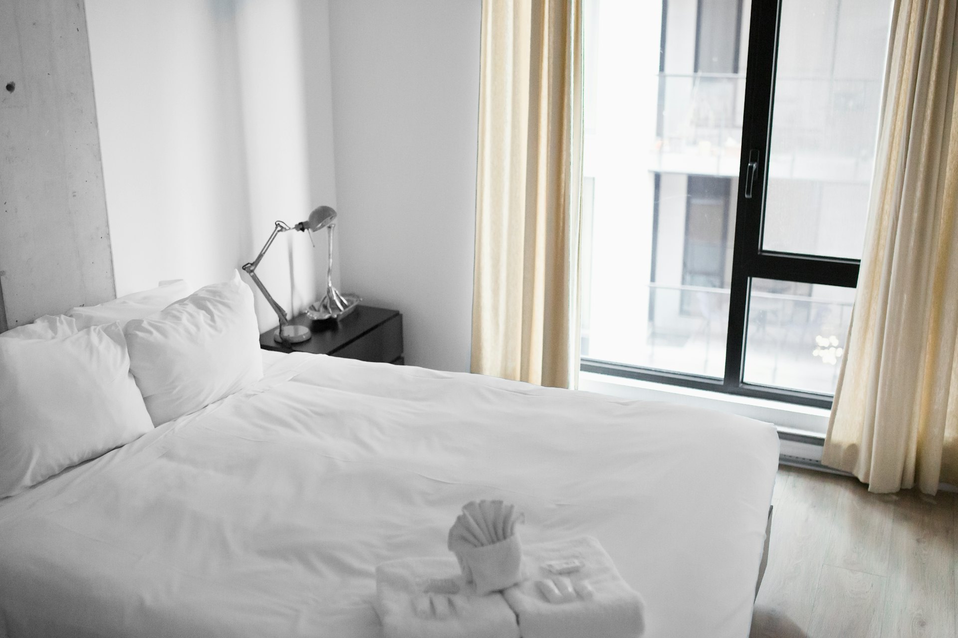 Chambre au lit blanc près d’une grande fenêtre